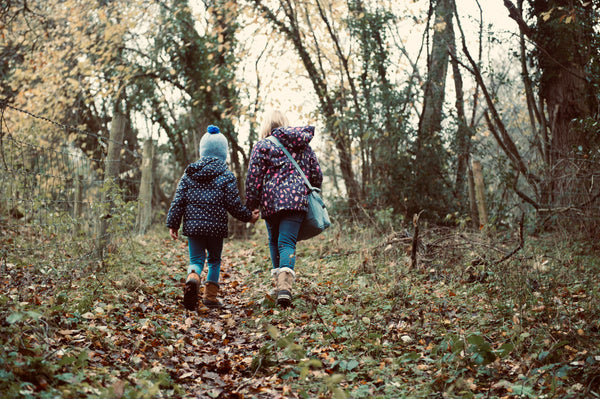 two children walk through the woods