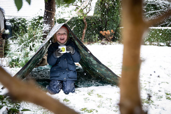 A child enjoying the winter outside with a hot drink