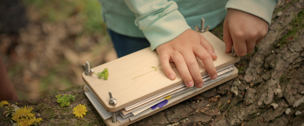 child's hands using flower press