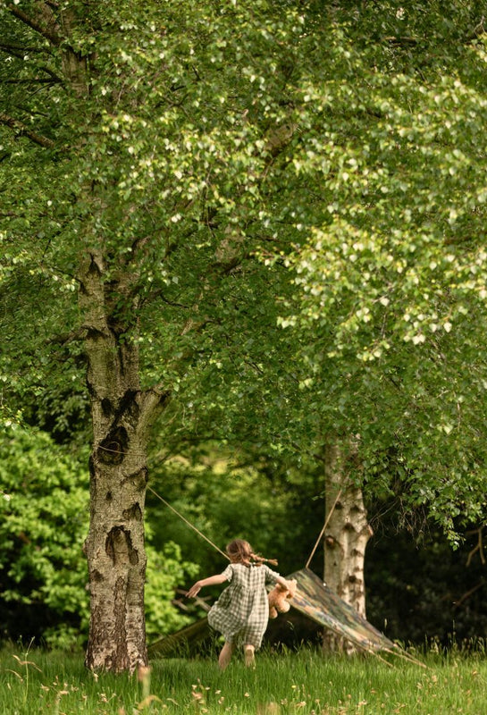 child running towards a den in a forest setting