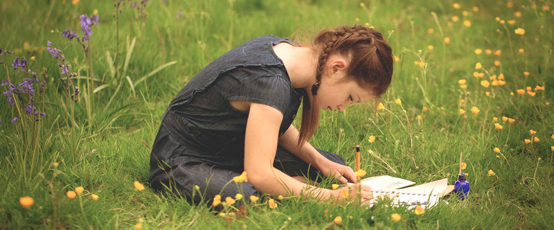 A girl playing outdoors with The Den Kit's New Herbarium Kit